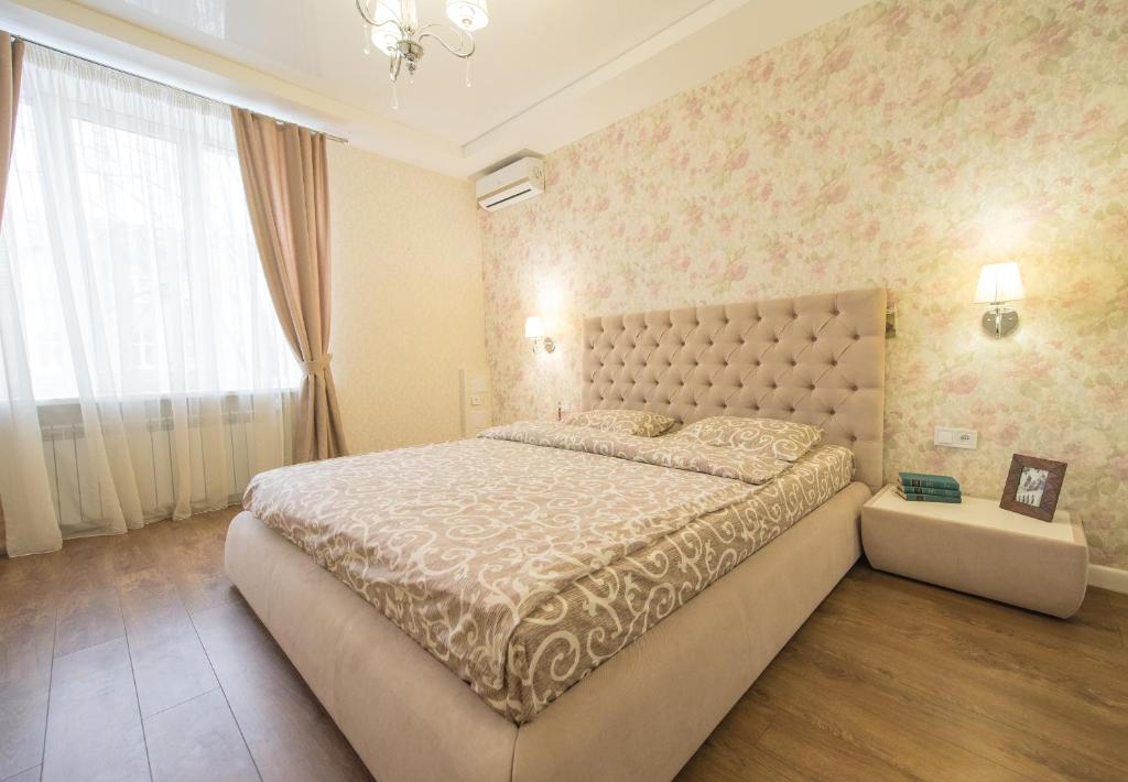 Un dormitorio con una cama grande y una ventana grande. en Apartment Atlantis, en Járkov