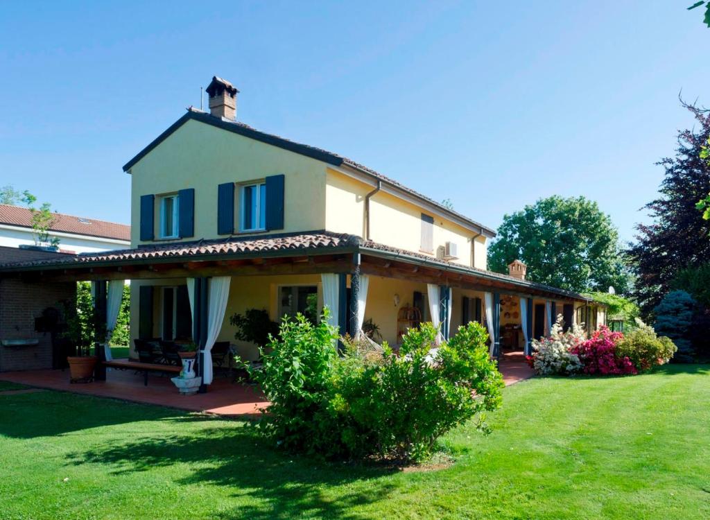 a large white house with a grass yard at Villa Bellaria B&B in Alseno