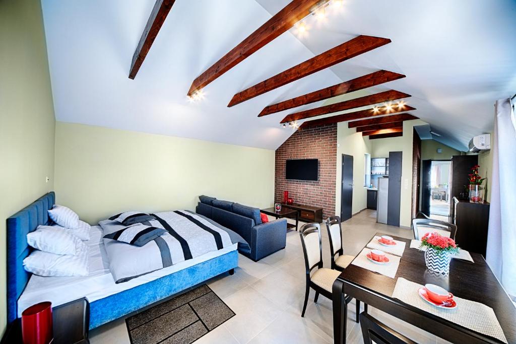 a bedroom and living room with a bed and a dining room at Apartamenty Salt Delux in Wieliczka