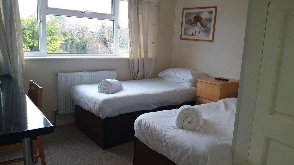 a small room with two beds and a window at Ava House Bed and Breakfast in Bicester