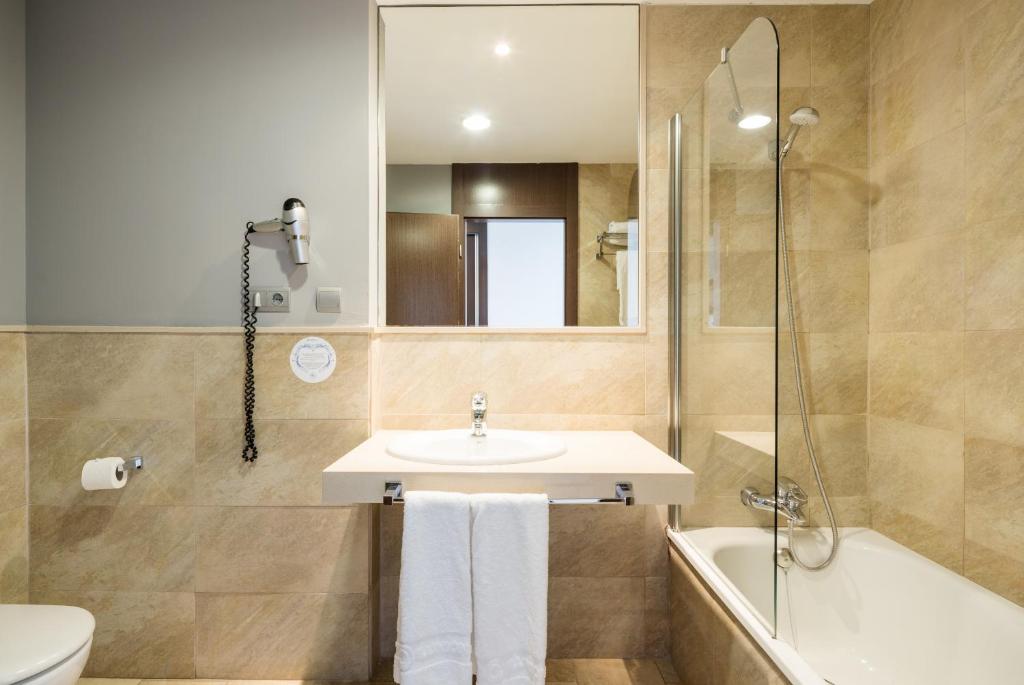 a bathroom with a sink and a shower and a toilet at Ilunion Calas de Conil in Conil de la Frontera