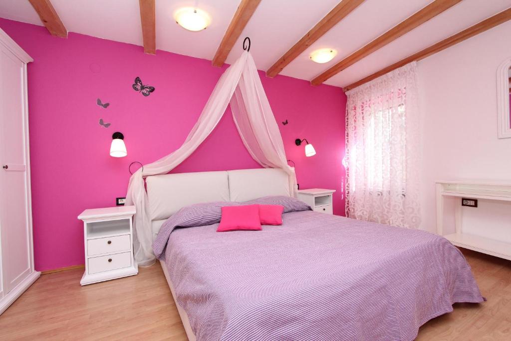 różowa sypialnia z łóżkiem z baldachimem w obiekcie Apartment Midea w Rovinj