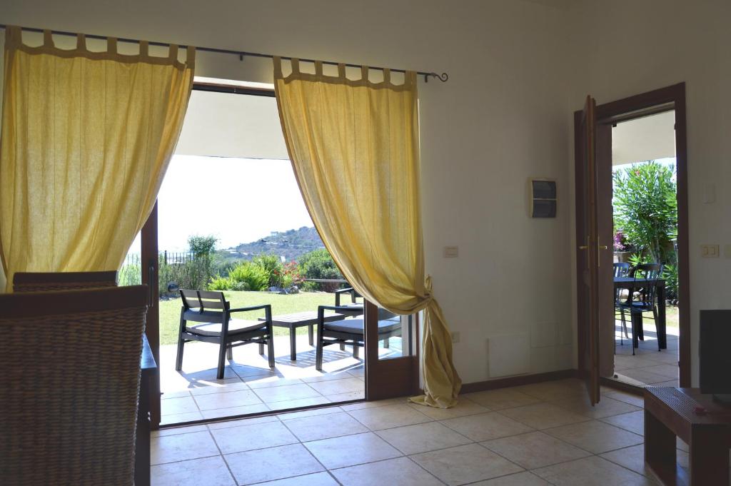 a room with a sliding glass door with a table and chairs at Sa Tirìa in Chia
