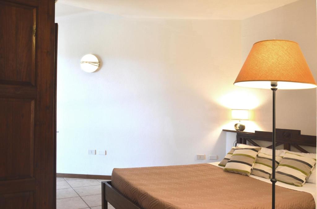 a bedroom with a bed with a lamp on it at Sa Tirìa in Chia