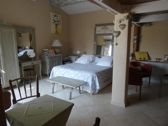 1 dormitorio con 1 cama, mesa y sillas en Chambre d'hôte Anais, en Eyguières