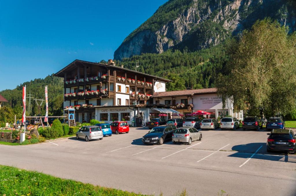 un gran edificio con coches estacionados en un estacionamiento en Hotel Laserz en Lienz