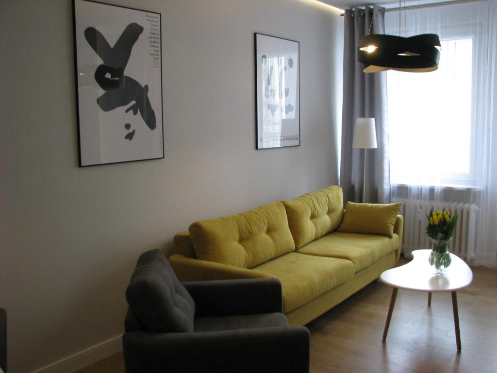 sala de estar con sofá amarillo y mesa en Apartament Relax Gdynia, en Gdynia