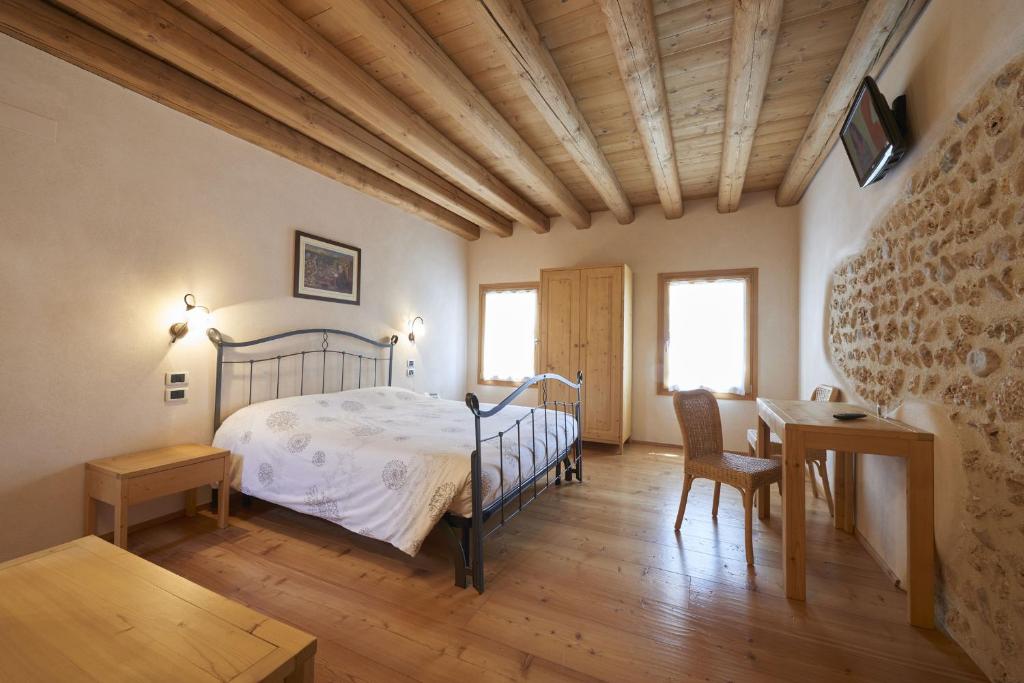 Giavera del MontelloにあるAgriturismo la paternaのベッドルーム1室(ベッド1台、テーブル、椅子付)