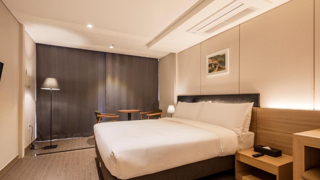 First Stay Hotel tesisinde bir odada yatak veya yataklar