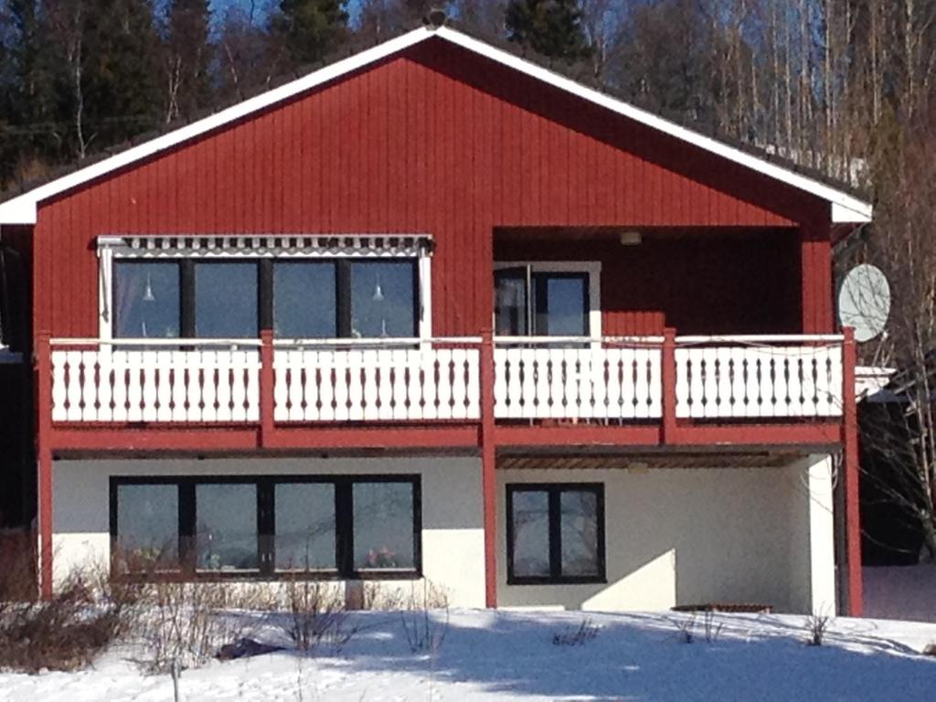 a red and white house with a white balcony at Funäs Fjäll Lägenhet in Funäsdalen