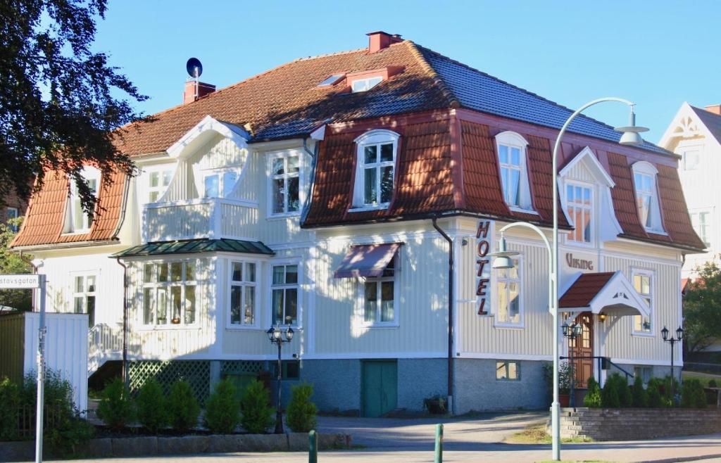 uma grande casa branca com um telhado vermelho em Hotell Viking em Uddevalla