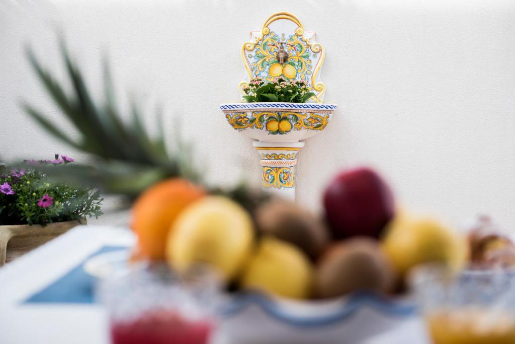 a bowl of fruit on a table with a vase at Appartamento Martina in San Vito lo Capo