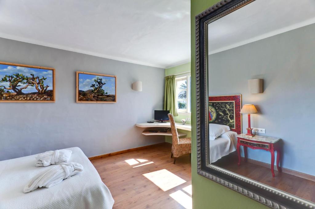 a mirror in a room with a bed and a desk at Casa de Hilario in Yaiza