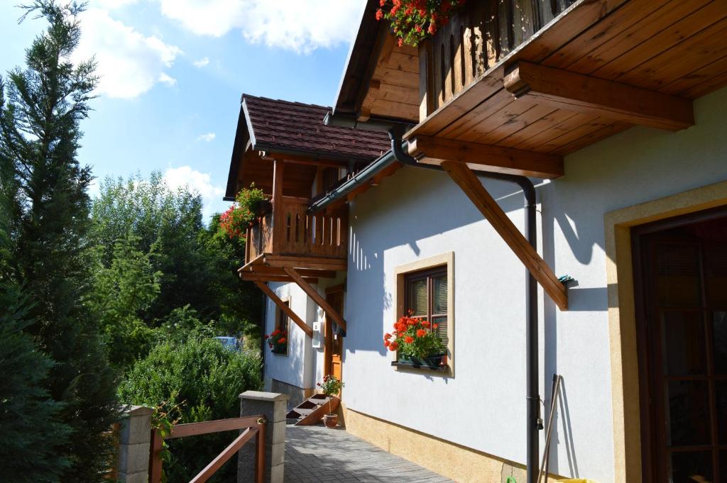 een huis met een balkon met bloemen in een raam bij Pension Druhý domov in Nový Bor