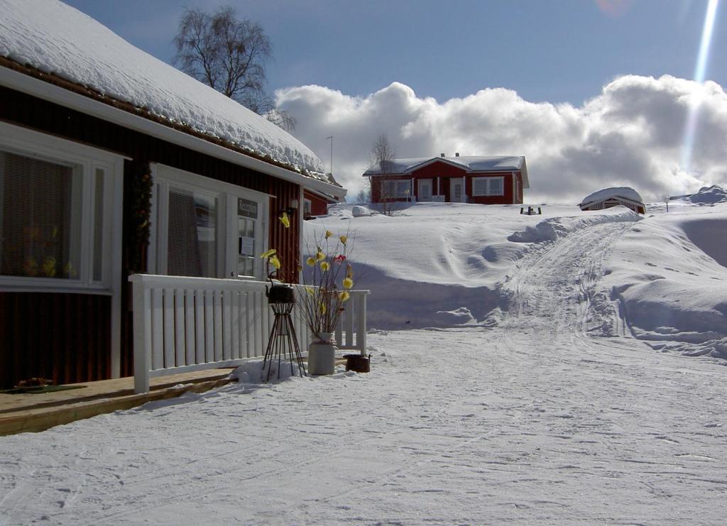 un patio cubierto de nieve junto a una casa con un montón de nieve en Lomamaja Pekonen Apartments, en Muonio