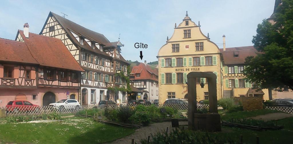 a group of buildings in a town with cars parked at Gîte "Le cosy" in Turckheim