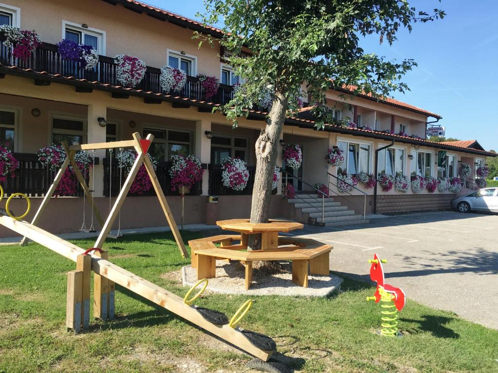 una mesa de picnic y un árbol frente a un edificio en Gostisce Golob, en Zgornja Polskava