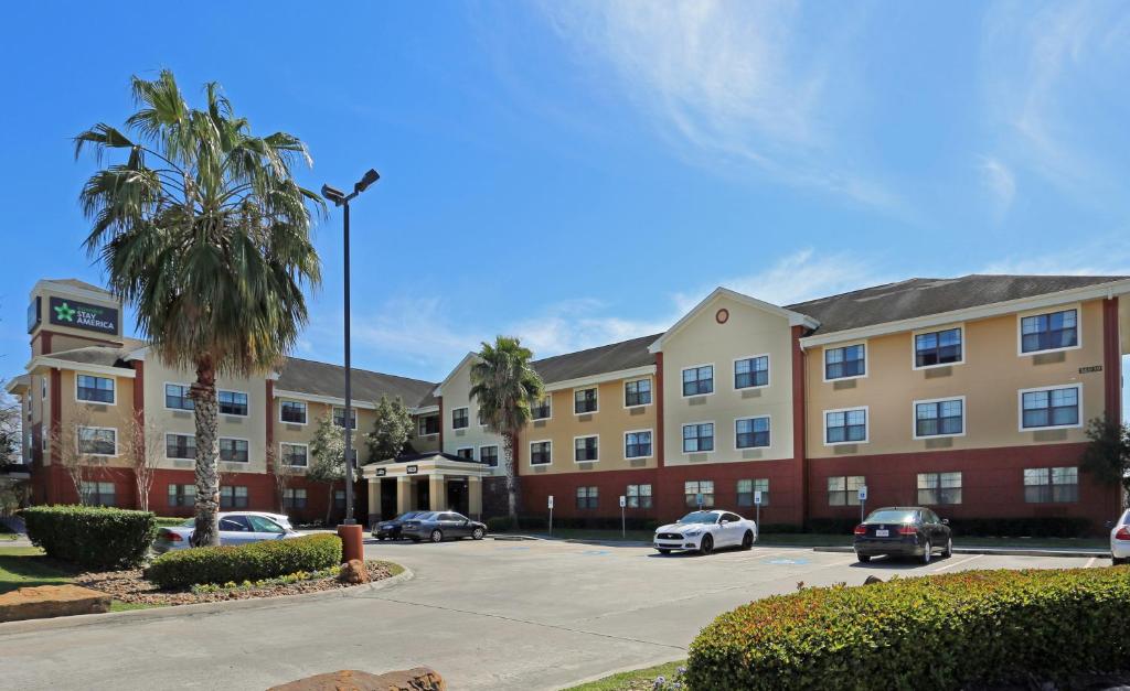 ein großes Gebäude mit Autos auf einem Parkplatz in der Unterkunft Extended Stay America Suites - Houston - Willowbrook - HWY 249 in Houston