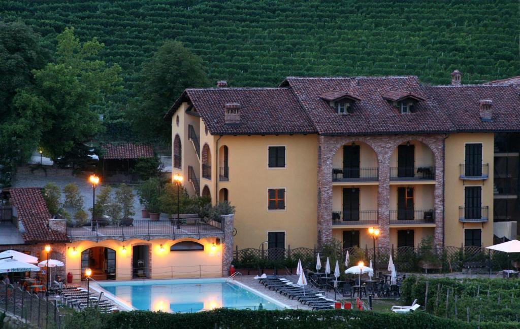 un hotel con piscina di fronte a un edificio di Hotel Barolo a Barolo