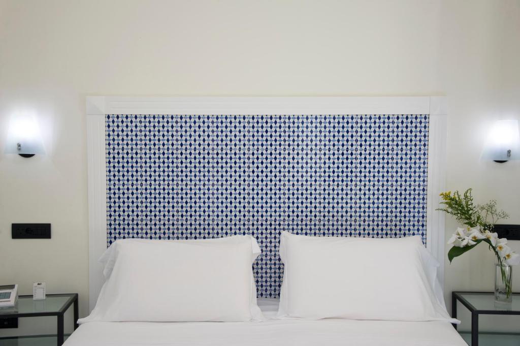 a bedroom with two white beds and blue tiles at Hotel Aurora in Amalfi