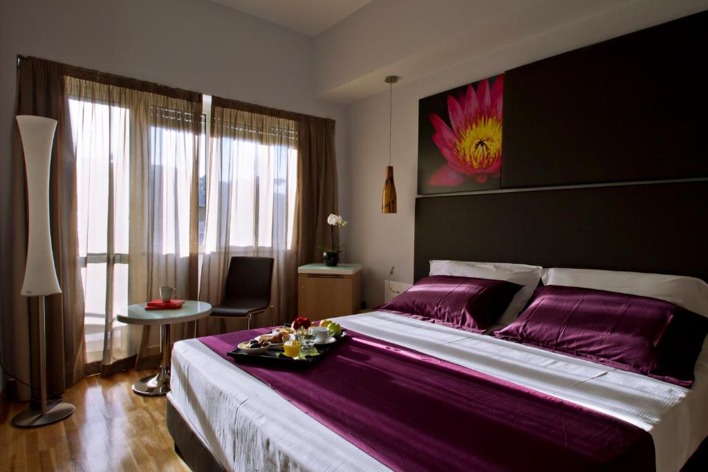 a bedroom with a large bed with a tray of food on it at Hotel Gravina San Pietro in Rome