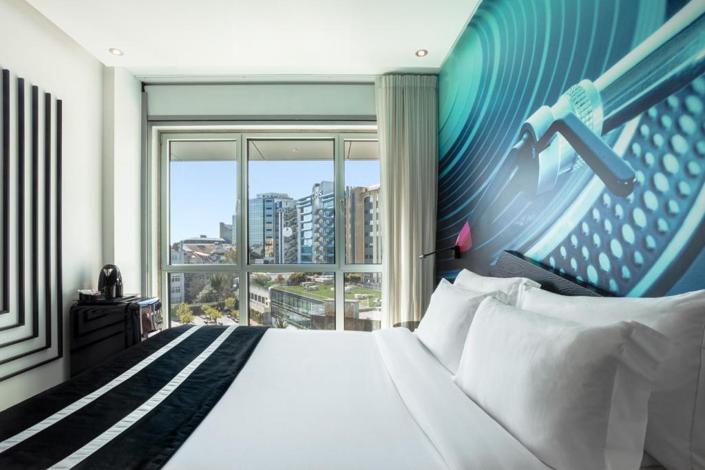 A bright music-themed room with a bed facing a city view.