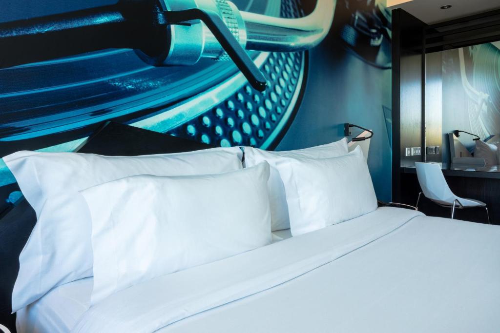 A close bedroom view showing crisp bedding, a music mural and a mirrored desk area.