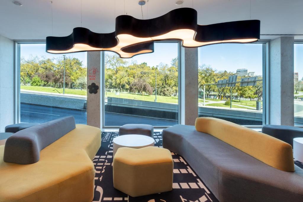 A bright lobby lounge facing a leafy park and city view.