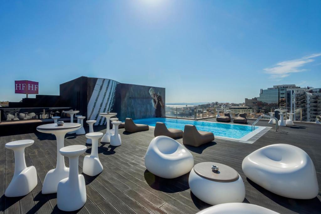 A rooftop terrace with a small pool, outdoor seating and broad city views.