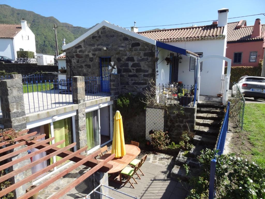 a house with a patio with a yellow umbrella at Casa do Rei in Furnas