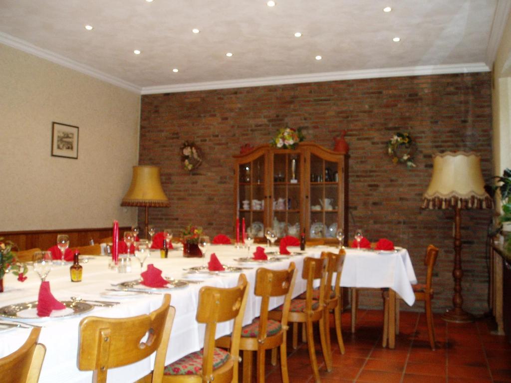 a large dining room with a long table with red decorations at Keglerbörse "Haus Ida" in Kleve