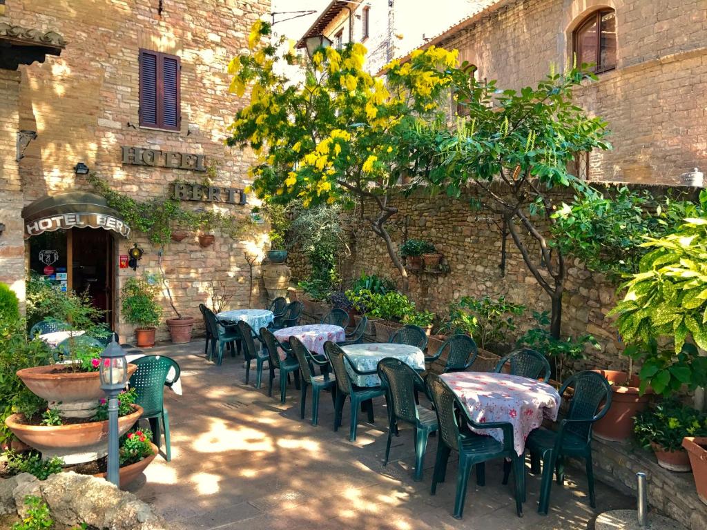 a group of tables and chairs in a courtyard at Hotel Berti in Assisi