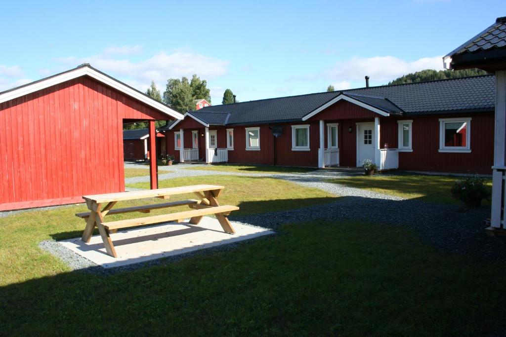 a wooden bench in front of a row of houses at Hybeltunet in Meråker