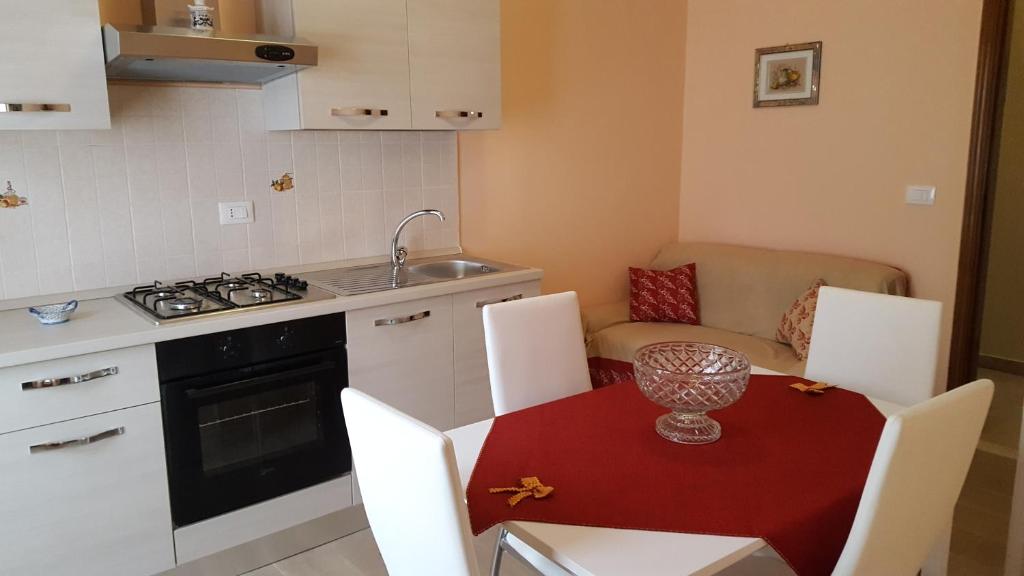 ジャルディーニ・ナクソスにあるAppartamenti Naxosのキッチン(テーブル、椅子付)、キッチン(シンク付)