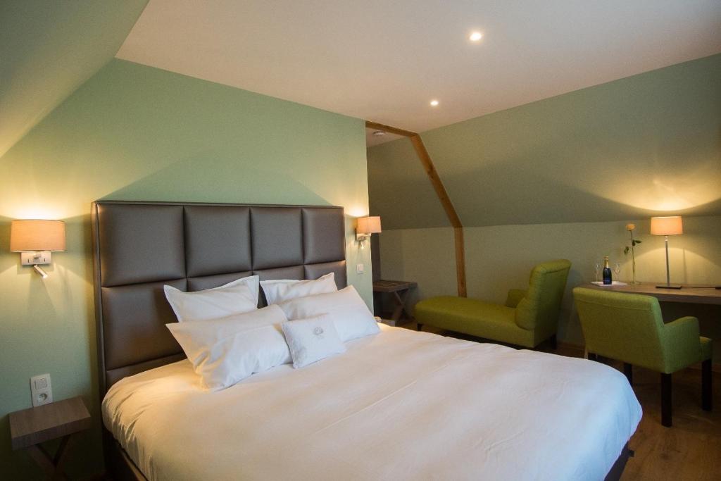 a bedroom with a large white bed with a green wall at De Gouden Klokke in Avelgem