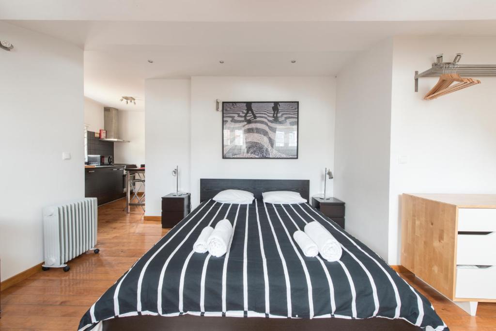 リスボンにあるCozy apartment in Bairro Altoのベッドルーム1室(黒と白のストライプの大型ベッド1台付)