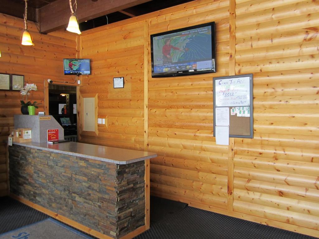 Shoal Lake Motor Inn في Shoal Lake: جدار خشبي مع بار عليه تلفزيون