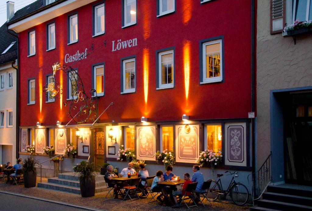 un grupo de personas sentadas en mesas fuera de un edificio en Gasthaus Löwen en Tuttlingen