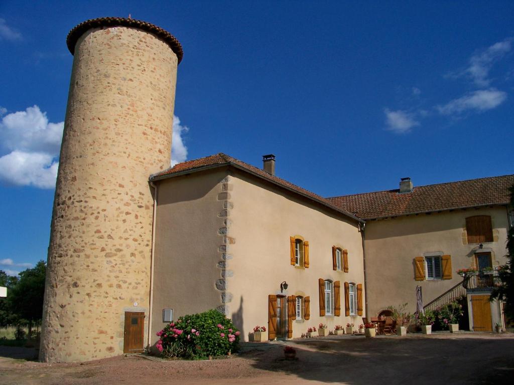 a building with a tower next to a building at Gite De La Tour De Rouilleres in Ambierle