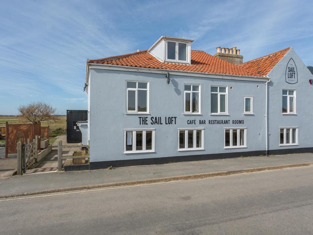 a white building with a sign on the side of it at The Sail Loft in Southwold