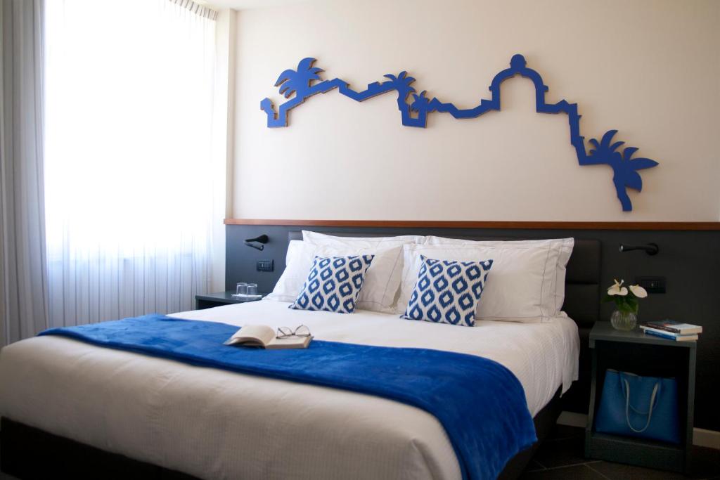 een slaapkamer met een groot bed met een blauw hoofdeinde bij Foyer in Cagliari