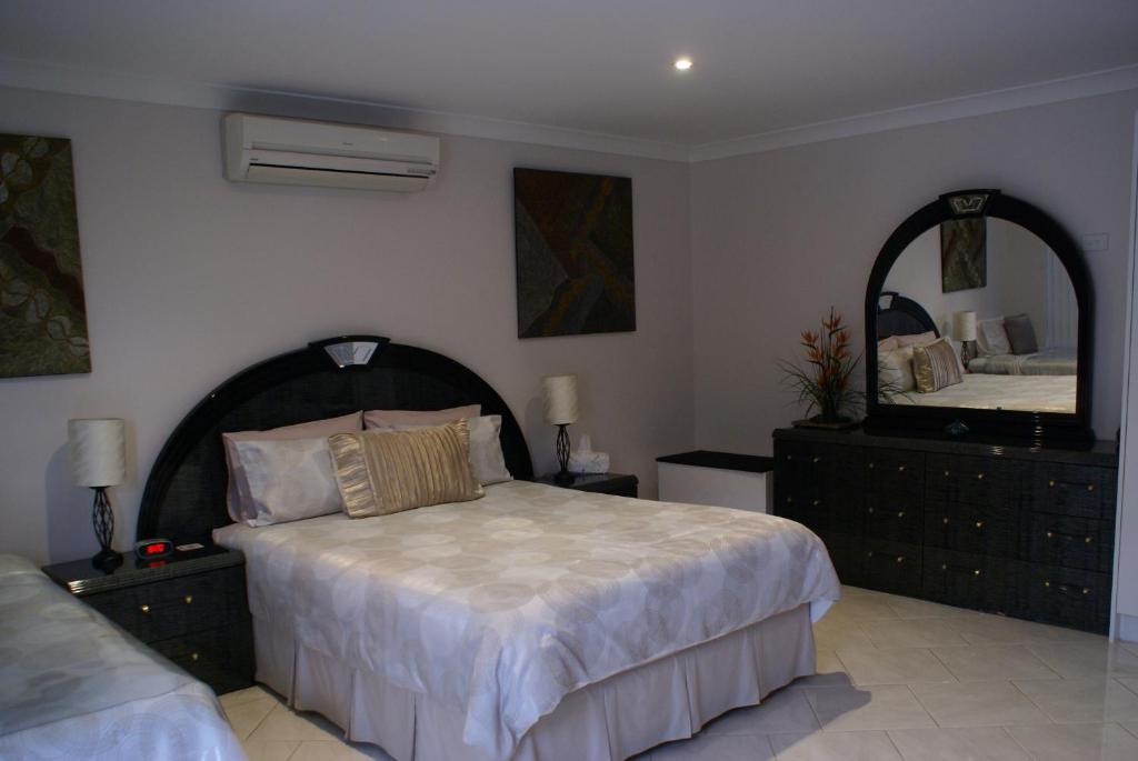 una camera con un letto e un grande specchio di A Good Rest B & B a Alice Springs