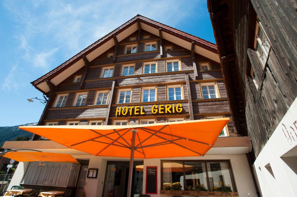 un paraguas naranja frente a un hotel serbia en Hotel Gerig, en Wassen