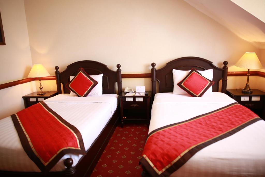 Postel nebo postele na pokoji v ubytování Sammy Dalat Hotel