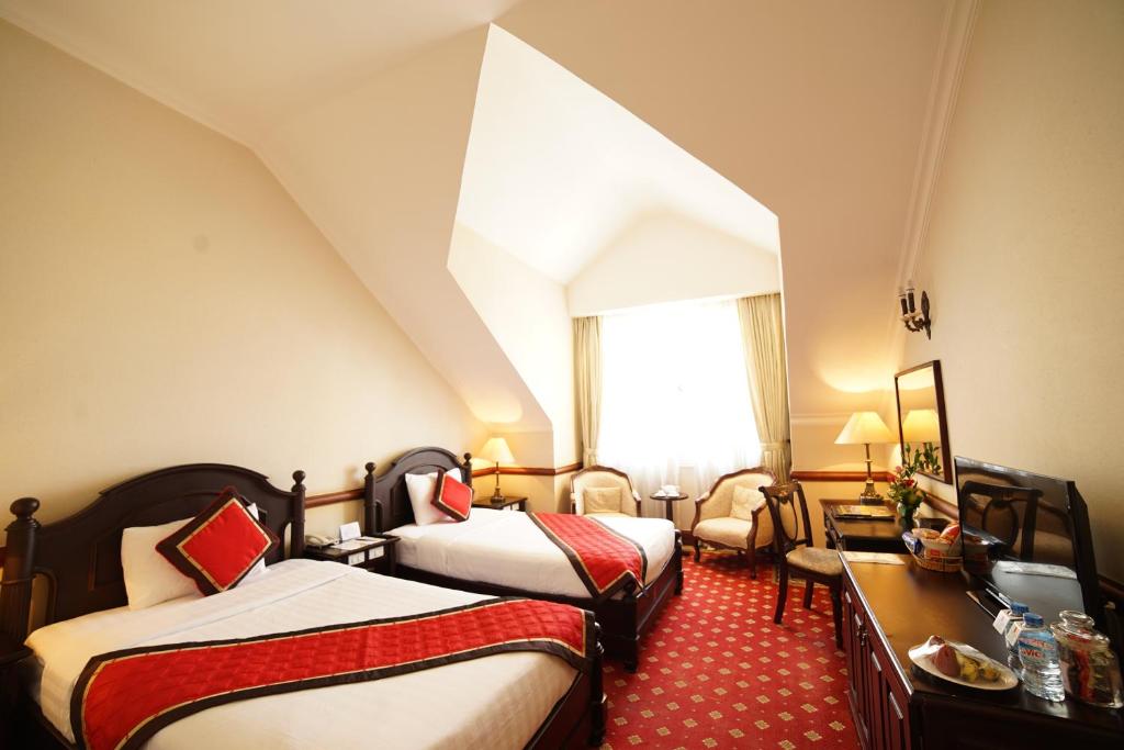 Postel nebo postele na pokoji v ubytování Sammy Dalat Hotel