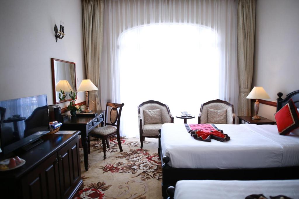 Postel nebo postele na pokoji v ubytování Sammy Dalat Hotel