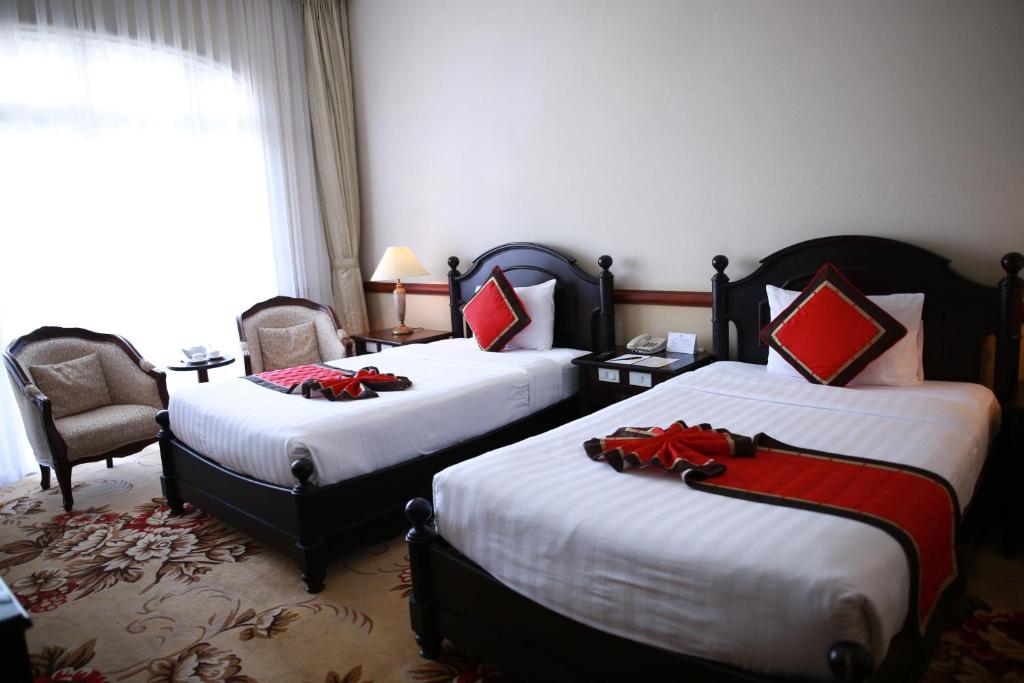 Postel nebo postele na pokoji v ubytování Sammy Dalat Hotel