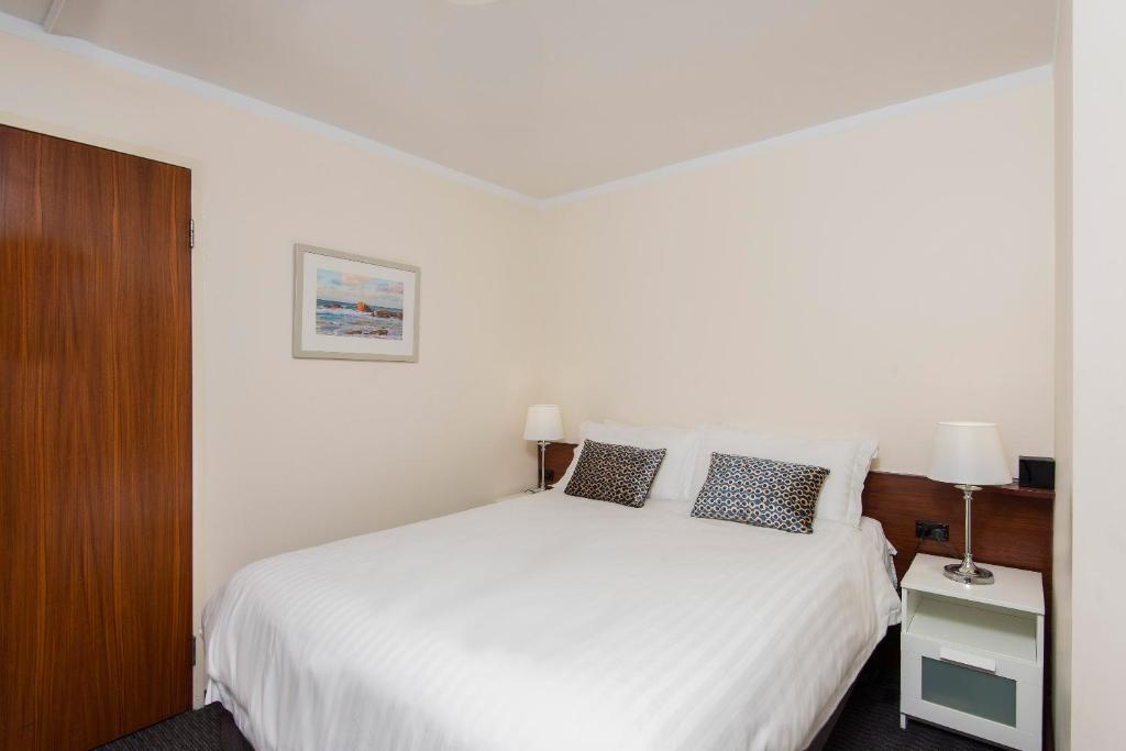 a bedroom with a bed and a dresser at Trinity on Hampden in Perth
