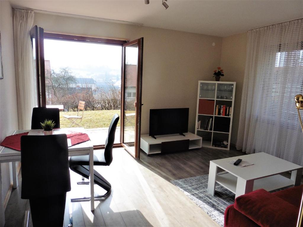 ein Wohnzimmer mit einem Esstisch und einem TV in der Unterkunft Ferienwohnung ,,Wingertsberg" in Ebrach