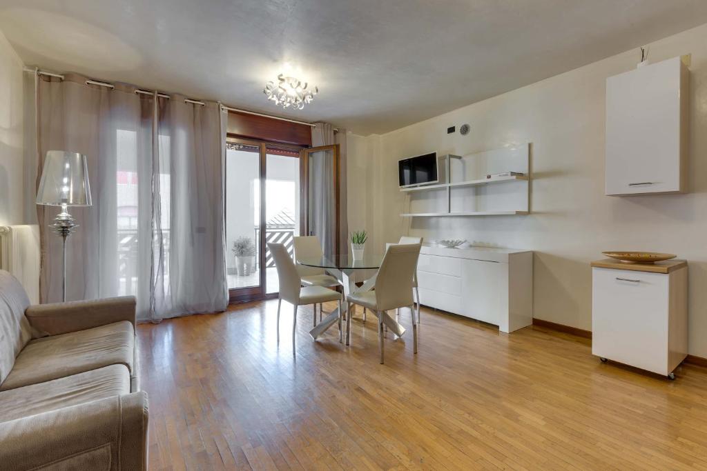 a living room with a table and chairs and a kitchen at Quartiere Padova 2000 in Padova